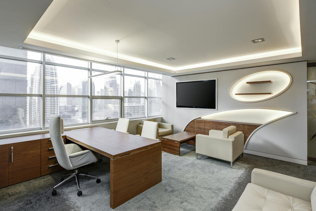 a modern executive office with a large minimalist desk, clean lines, comfortable chairs, and a wall‑mounted TV, designed in a bright, professional workspace style that suggests clarity, leadership, and contemporary corporate design.