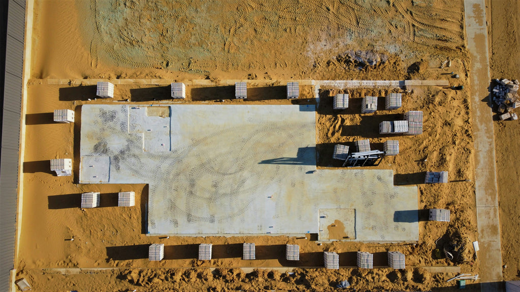foundation preparation with poured concrete and exposed rebar, showing a solid structural base that symbolizes stability, grounded strength and the beginning of a reliable architectural framework.