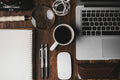 Wooden desk with a laptop, coffee cup, notebook, and office supplies — a calm symbol of focus, intentional work, and grounded leadership.