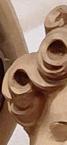 a close‑up of a carved wooden curl, soft and luminous, symbolizing quiet authority and gentle leadership — a reminder of strength expressed through tenderness and presence.