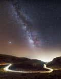 a starry night sky over a winding road in a mountainous landscape, a quiet scene of darkness, depth, and natural light — a calm, expansive setting symbolizing reflection, direction, and inner clarity.