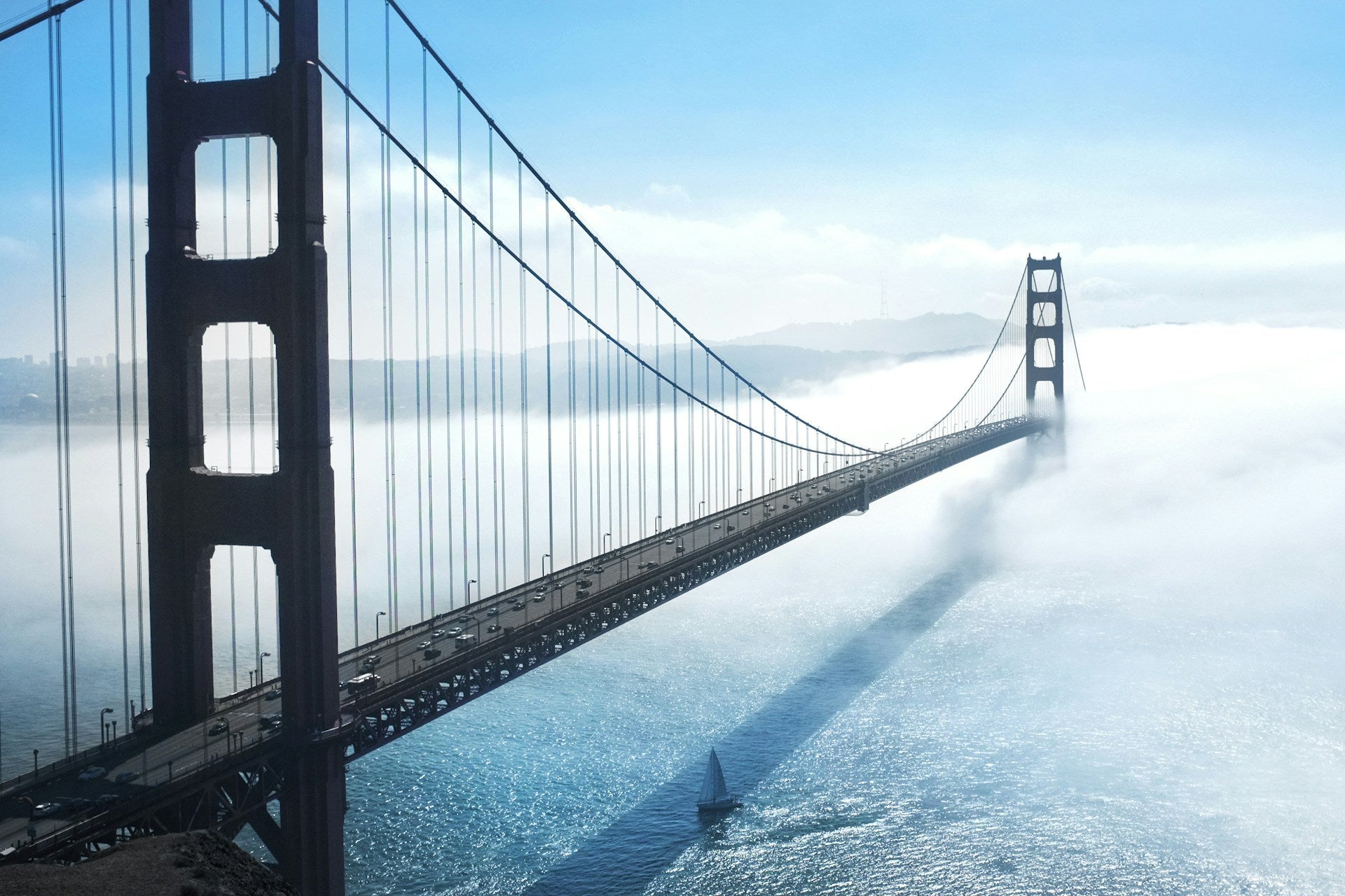Golden Gate Bridge in mist with a sailboat in the foreground, symbolizing quiet leadership, transition, and steady movement through uncertainty.
