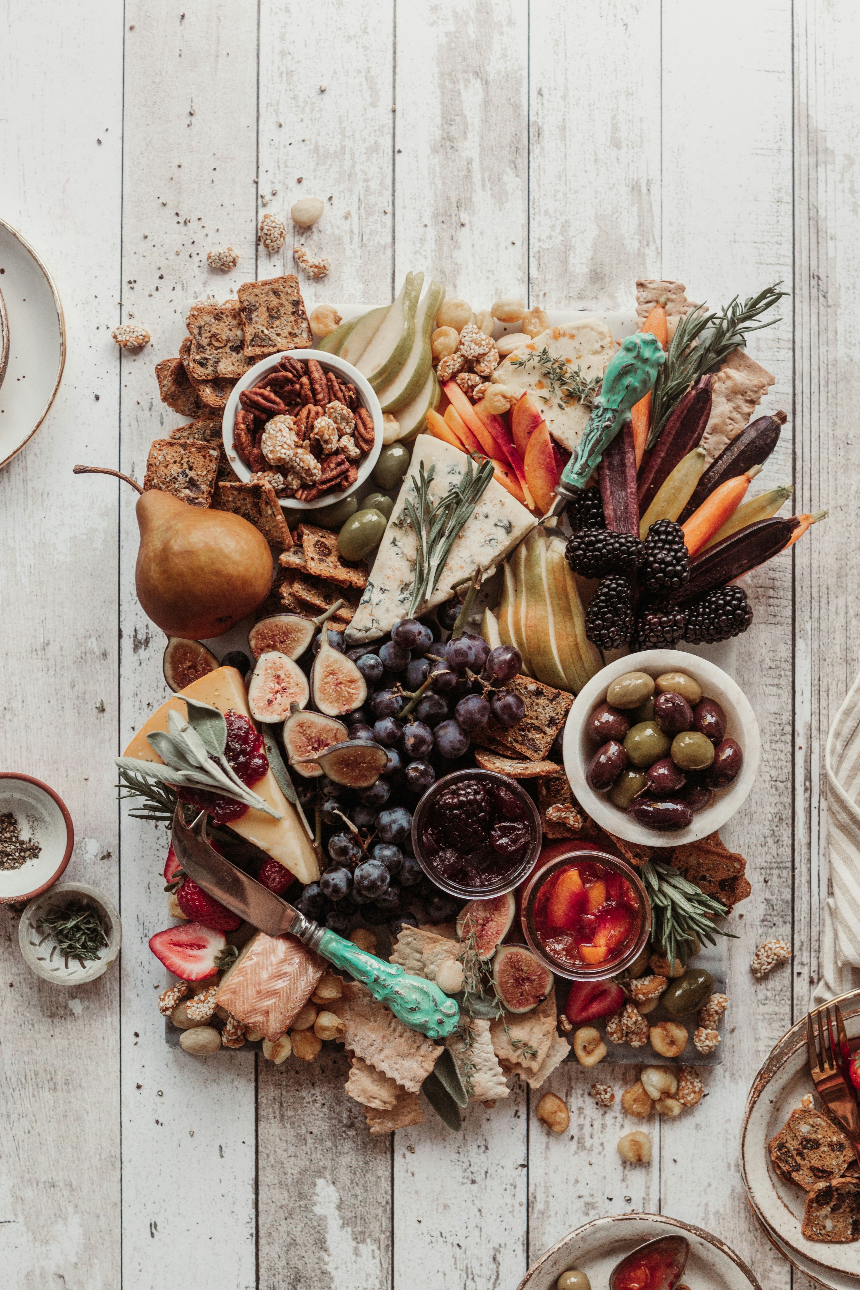 a  natural spread of fruits, cheese, bread and vegetables on a wooden table, symbolizing grounded openness, quiet abundance and the gentle nourishment that supports inner clarity.